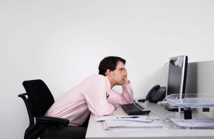 Bored Male Office Worker At Desk
