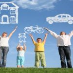 family of four on grass with hands up