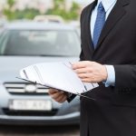 man with car documents outside