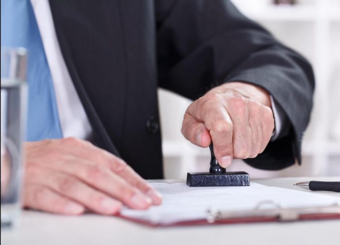 man-in-suit-using-stamp-on-paper