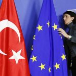 A staff adjusts European Union and Turkish flags ahead of the arrival of Turkey’s PM Erdogan at the EU Commission headquarters in Brussels