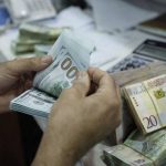 A man counts U.S. dollars at a currency exchange office in central Tripoli