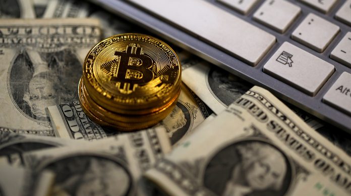 Bitcoin (virtual currency) coins placed on Dollar banknotes are seen in this illustration picture