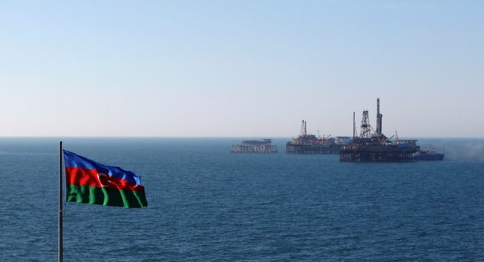 An Azerbaijan state flag flutters in the wind on an oil platform in the Caspian Sea