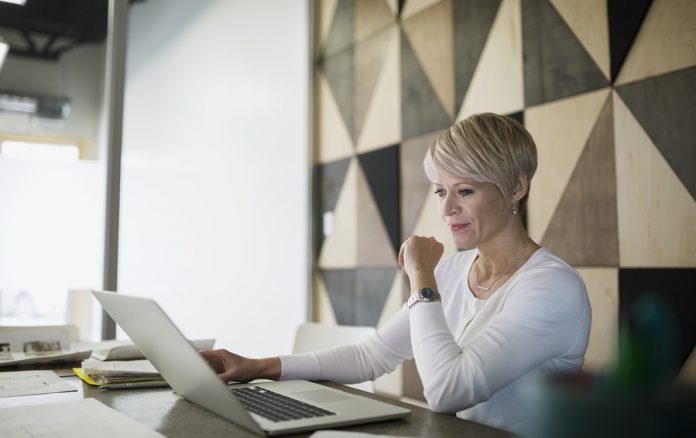 Focused businesswoman working at laptop in conference room