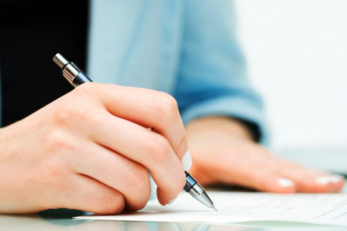 bigstock-Female-hand-signing-contract-document